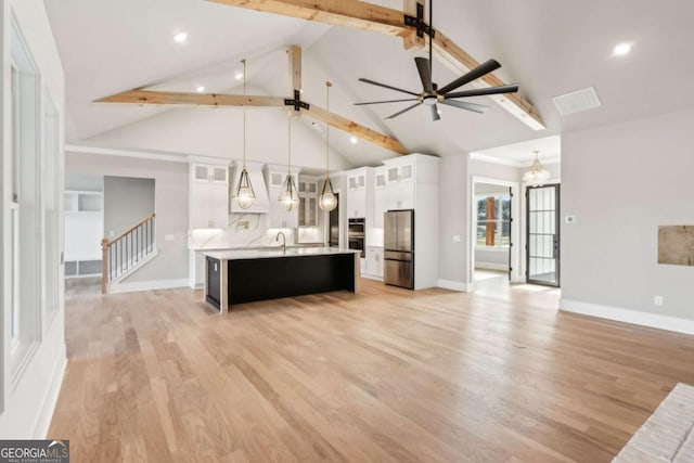 kitchen with decorative light fixtures, white cabinets, light countertops, freestanding refrigerator, and glass insert cabinets