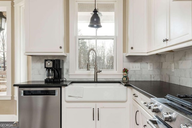 kitchen featuring appliances with stainless steel finishes, dark countertops, and white cabinets