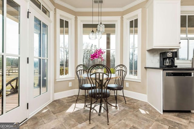 dining room featuring ornamental molding, stone finish flooring, a notable chandelier, and baseboards