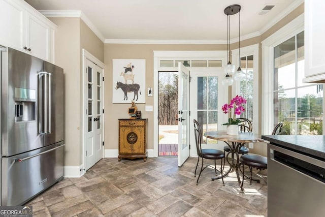 dining space with visible vents, baseboards, ornamental molding, stone finish flooring, and french doors