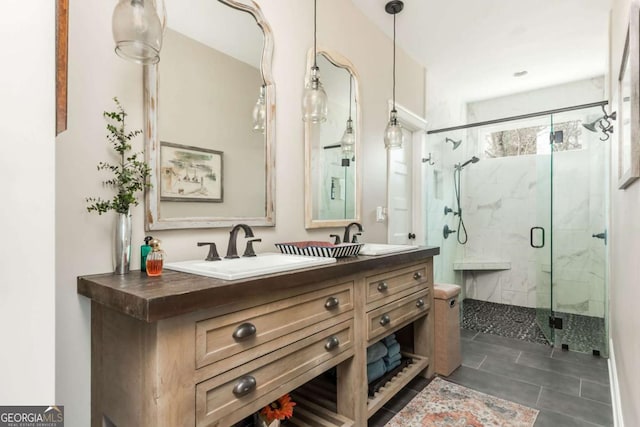 bathroom with a sink, a marble finish shower, and double vanity