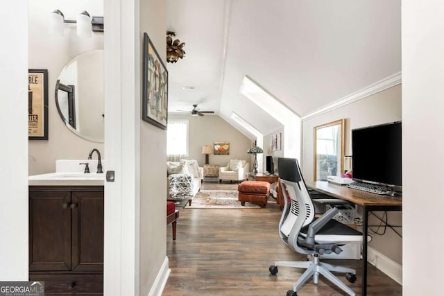 office area featuring vaulted ceiling, dark wood-style flooring, a sink, and baseboards