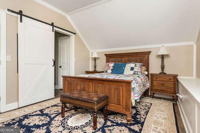 bedroom with lofted ceiling, a barn door, and ornamental molding