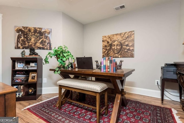 office space with visible vents, baseboards, and wood finished floors