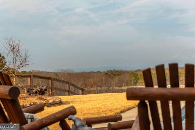 view of yard with fence and a rural view