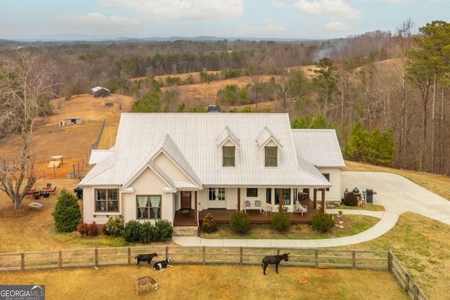 cape cod home with a porch, a front yard, metal roof, fence private yard, and driveway