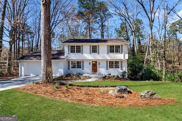 view of front of home with a garage, driveway, and a front yard