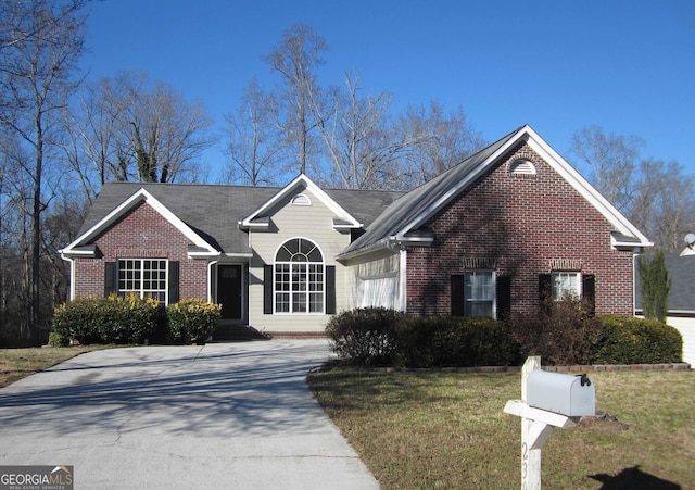 ranch-style house featuring driveway, a front yard, a garage, and brick siding