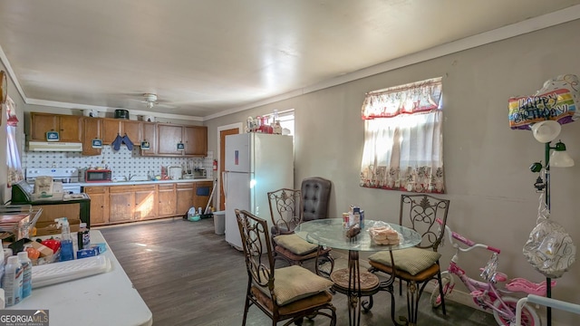 dining area featuring dark wood-style floors, ceiling fan, and ornamental molding