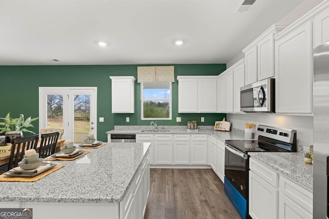 kitchen featuring light stone countertops, visible vents, appliances with stainless steel finishes, and white cabinets