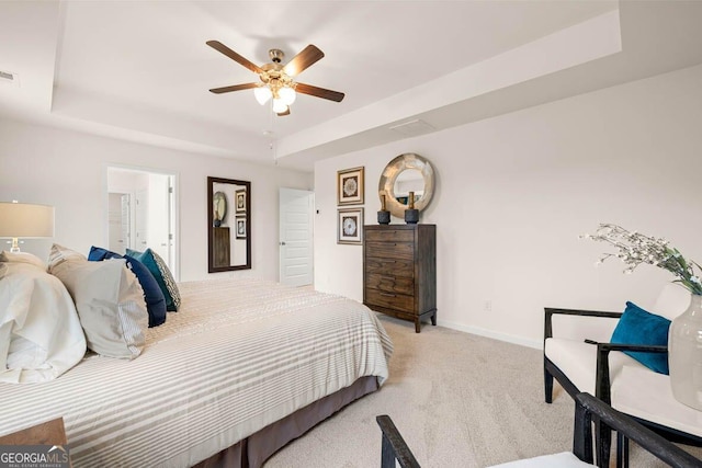 bedroom featuring baseboards, a tray ceiling, visible vents, and light colored carpet