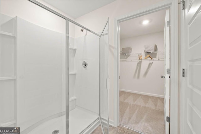 full bath featuring a stall shower and a spacious closet