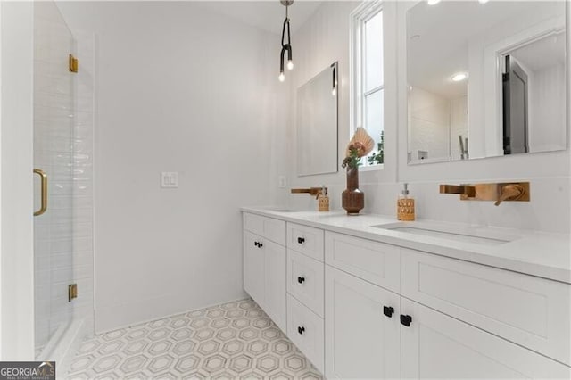 bathroom featuring double vanity, a stall shower, and a sink