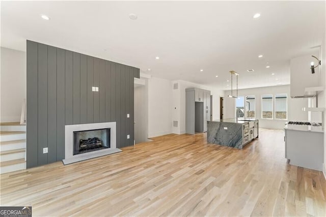 living room featuring light wood finished floors, a fireplace, and recessed lighting