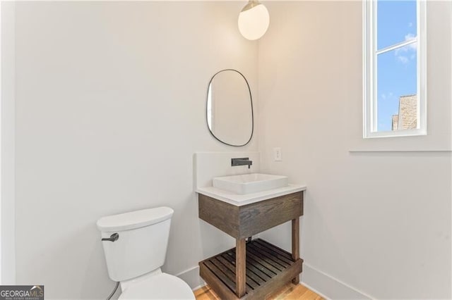 bathroom featuring a sink, toilet, and baseboards