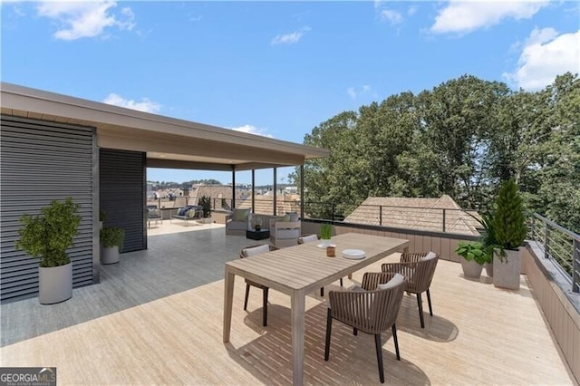 wooden terrace with outdoor dining area and fence