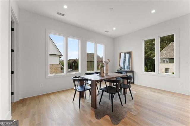 dining room with light wood finished floors, baseboards, visible vents, and recessed lighting