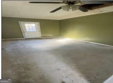 empty room featuring a ceiling fan and concrete flooring