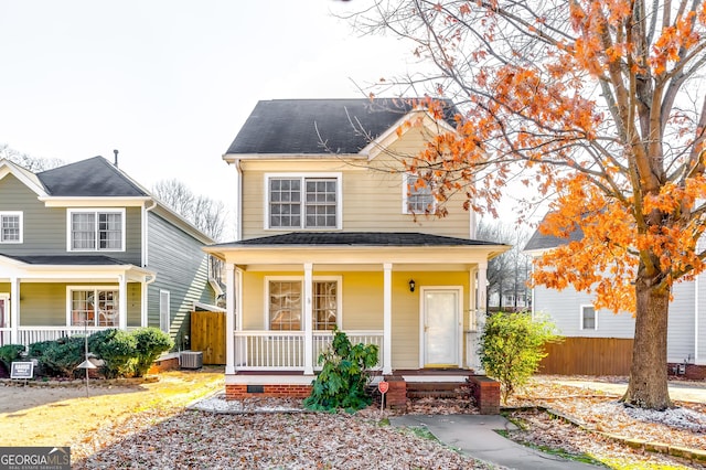 view of front of home featuring central AC unit, covered porch, a shingled roof, and fence