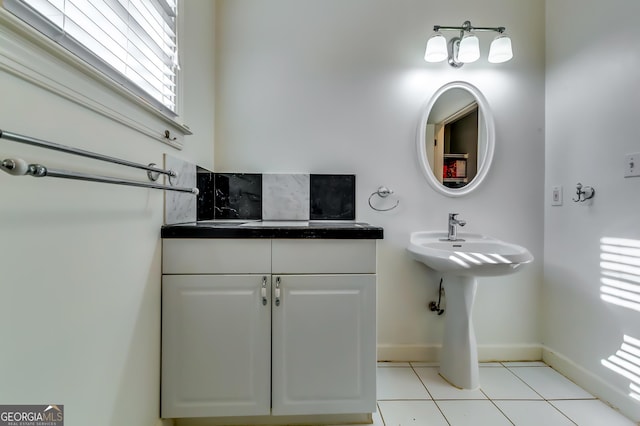 bathroom featuring decorative backsplash, tile patterned flooring, and baseboards