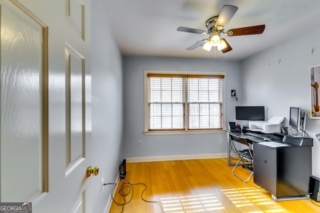 home office with baseboards, a ceiling fan, and light wood-style floors