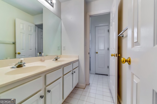 full bathroom with tile patterned flooring, a sink, baseboards, and double vanity