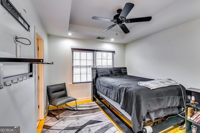 bedroom with ceiling fan, recessed lighting, visible vents, baseboards, and a tray ceiling