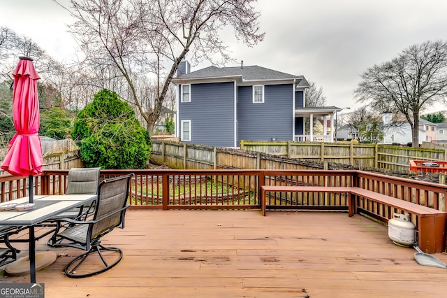 wooden terrace featuring a fenced backyard and outdoor dining area