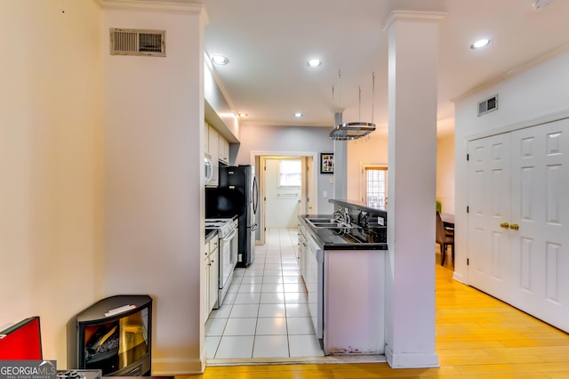 kitchen featuring dark countertops, white appliances, white cabinetry, and visible vents