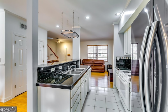 kitchen with tile countertops, visible vents, white cabinetry, a sink, and white appliances