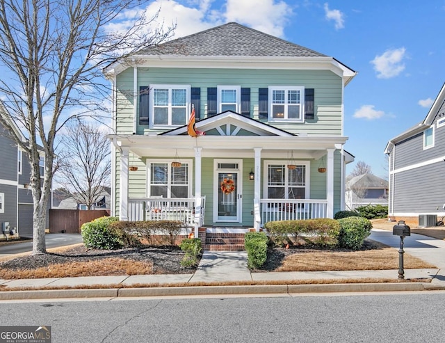 view of front of property featuring fence, a porch, and central AC