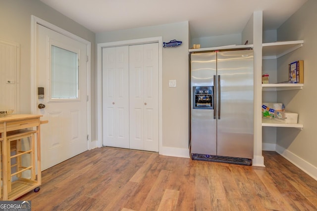 kitchen with baseboards, wood finished floors, and stainless steel fridge with ice dispenser