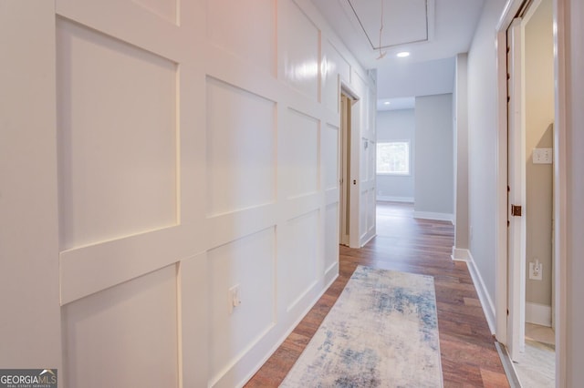 corridor featuring dark wood-style floors, recessed lighting, attic access, and baseboards