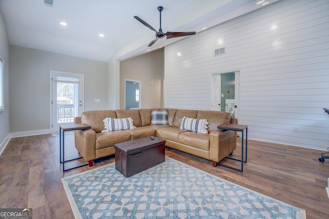 living area with high vaulted ceiling, baseboards, visible vents, and wood finished floors