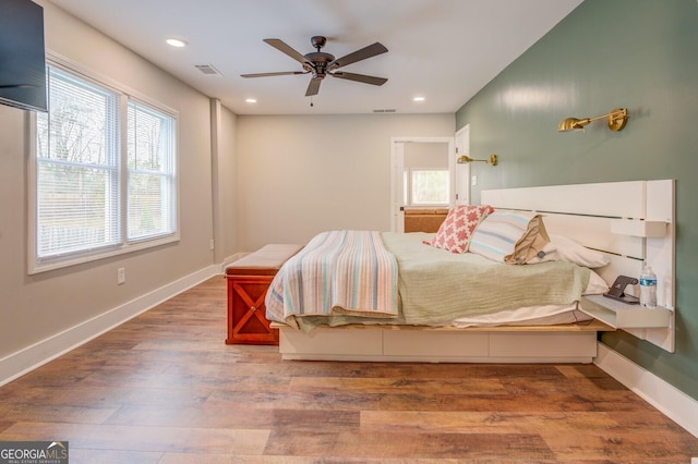 bedroom with recessed lighting, wood finished floors, visible vents, and baseboards