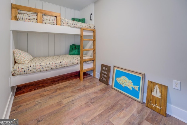 bedroom with baseboards and wood finished floors