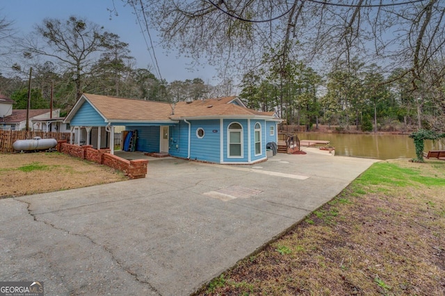 view of front of house featuring concrete driveway and a water view