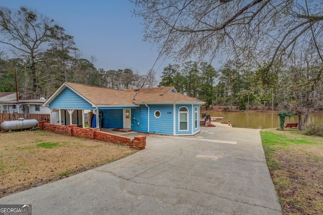 ranch-style home featuring a water view, driveway, and a front yard