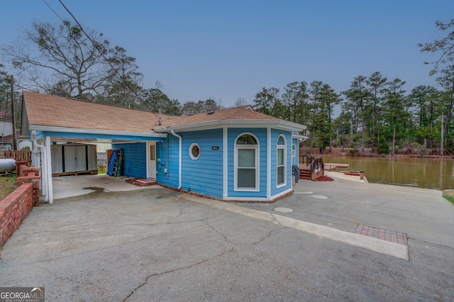 view of front of property with a water view and driveway