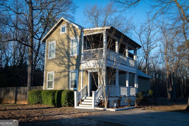 view of front of home with a balcony and fence