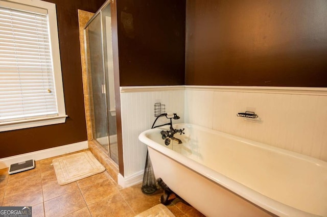 full bathroom featuring tile patterned flooring, a soaking tub, wainscoting, and a shower stall