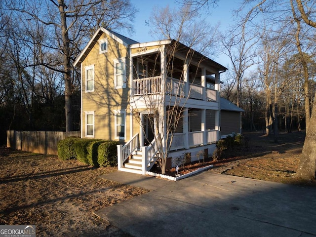 view of front of house featuring a balcony and fence