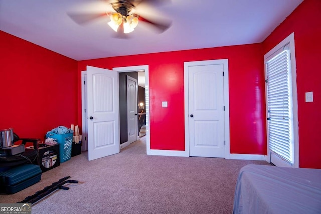 bedroom featuring a ceiling fan, light colored carpet, and baseboards