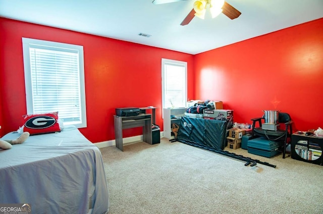 carpeted bedroom featuring baseboards, visible vents, and ceiling fan