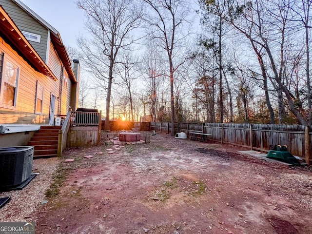 view of yard with a fenced backyard, cooling unit, and a hot tub