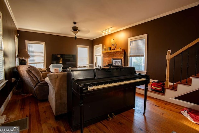 living room with ornamental molding, stairway, wood finished floors, and a ceiling fan