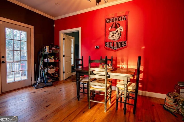 dining area with crown molding, baseboards, and wood finished floors