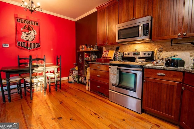 kitchen featuring a chandelier, light wood-style floors, appliances with stainless steel finishes, backsplash, and crown molding