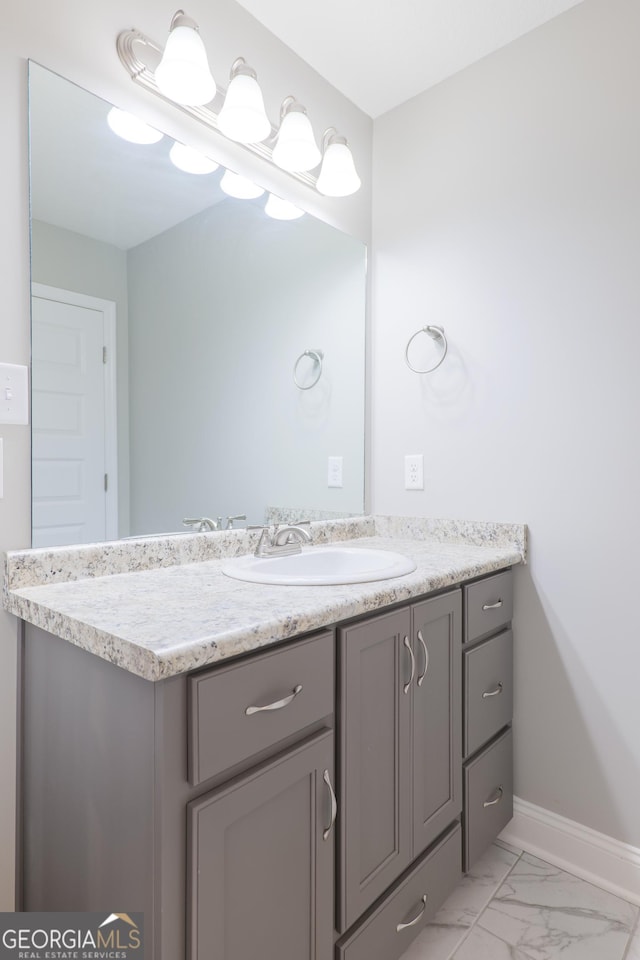 bathroom featuring marble finish floor, vanity, and baseboards