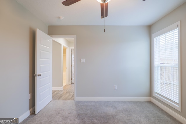 unfurnished room featuring ceiling fan, baseboards, and light colored carpet